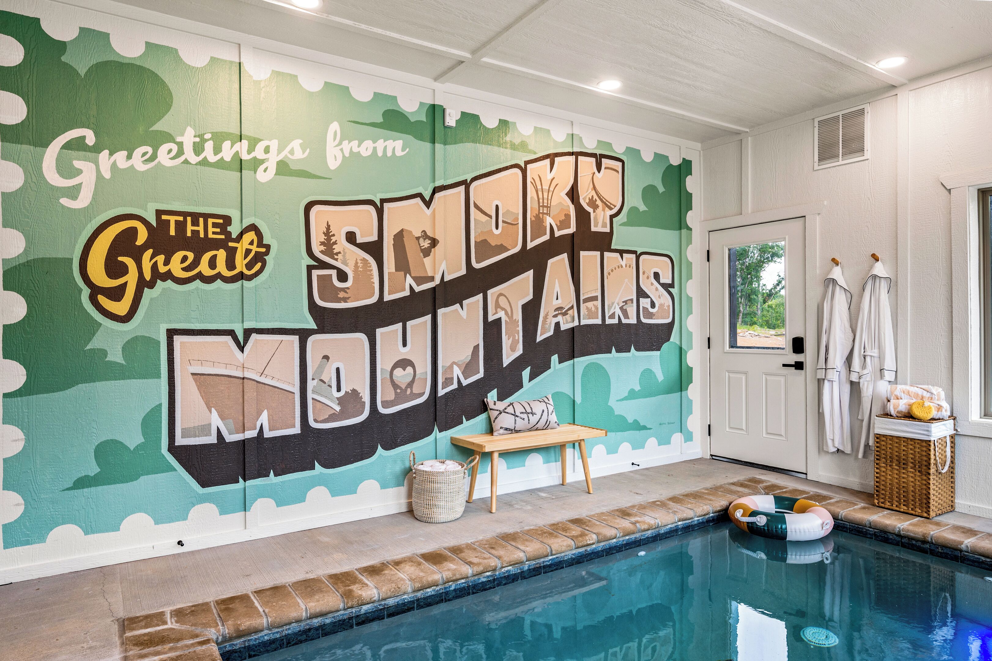 A pool area with a mural reading "Greetings from The Great Smoky Mountains."