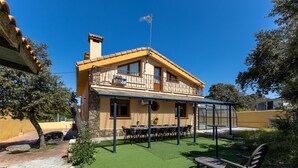 Un edificio di due piani con un balcone, posti a sedere all'aperto e un patio coperto.