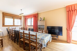 A dining area with a table, chairs, a television, and a cabinet. - Apartment 'Finca El Olivo' with Mountain View, Wi-Fi and Air Conditioning (Ituero y Lama)