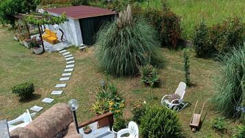 Un giardino pensile con zona barbecue, posti a sedere all'aperto e diverse piante.