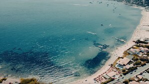An aerial view of a coastal area with a beach, boats, and a row of buildings with a pool. - Villa 'Le Gabian' with Sea View, Wi-Fi and Air Conditioning (Sainte Maxime)