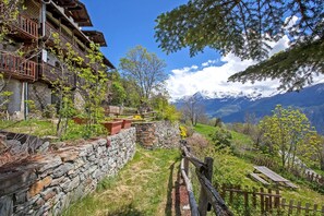 A stone wall, wooden fence, and a mountain view. - “Sabot” Room – Charm and Intimacy (Saint Pierre)