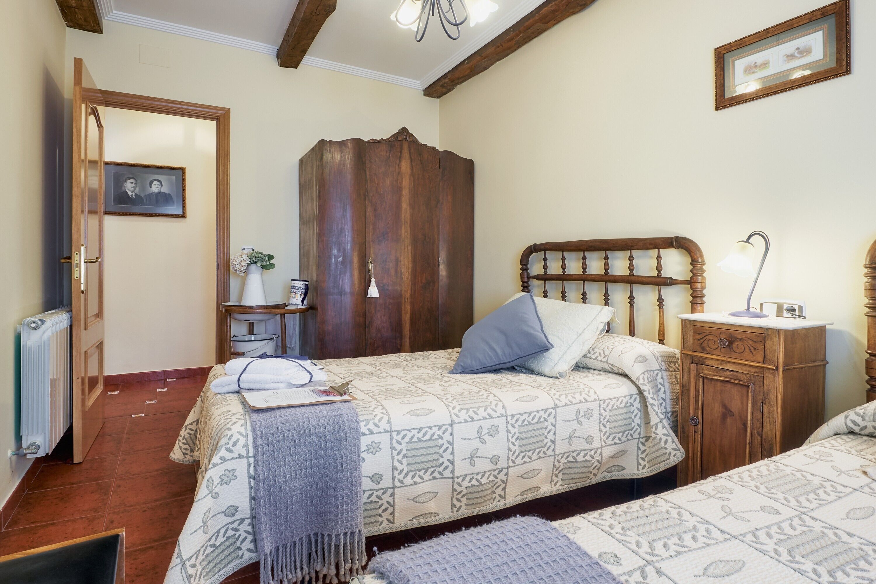A bedroom with a bed, bedside table, wardrobe, and a radiator.