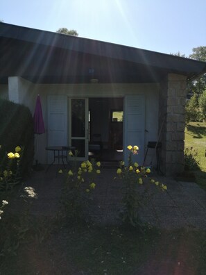 Une maison avec un patio, une porte et un mur en pierre.