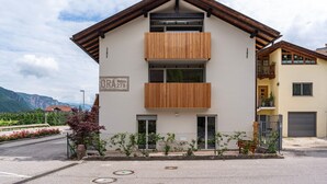 A modern building with a balcony, a garage, and a mountain view. - Apartment '1' with Mountain View, Wi-Fi and Air Conditioning (Auer)