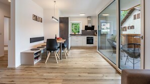 A modern kitchen with a dining area, a built-in bench, and a glass wall with a view. - Apartment '2' with Mountain View, Wi-Fi and Air Conditioning (Auer)