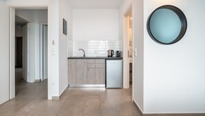 A modern kitchen with a dishwasher, a sink, and a coffee maker. There is a hallway leading to another room. - Apartment 'Tesoro Del Mare with Sea View 1' with Sea View, Wi-Fi and Air Conditioning (Pefki)