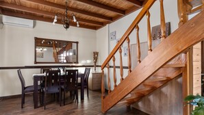 Ein Essbereich mit einer Holztreppe und einer Holzbalkendecke.