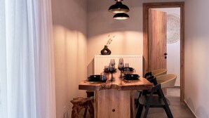 Un espace repas comprenant une table en bois, des chaises et un luminaire suspendu.
