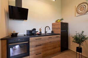 A compact kitchen with a stove, oven, sink, and a refrigerator.