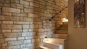 A staircase with stone walls and a modern light fixture. - Apartment 'Villa 2' with Mountain View, Balcony and Wi-Fi (Plati/Lasithi)
