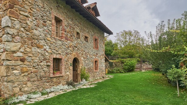 A stone building with a garden in front.