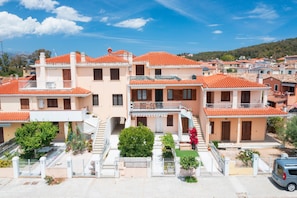 Zona residencial con edificios de tejas de barro, una escalera central y un pequeño árbol.