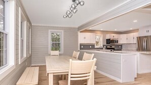 Una cocina moderna con armarios blancos, electrodomésticos de acero inoxidable y una isla central.