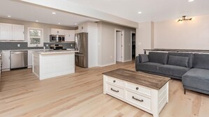 Una cocina moderna con armarios blancos, electrodomésticos de acero inoxidable y una isla central.