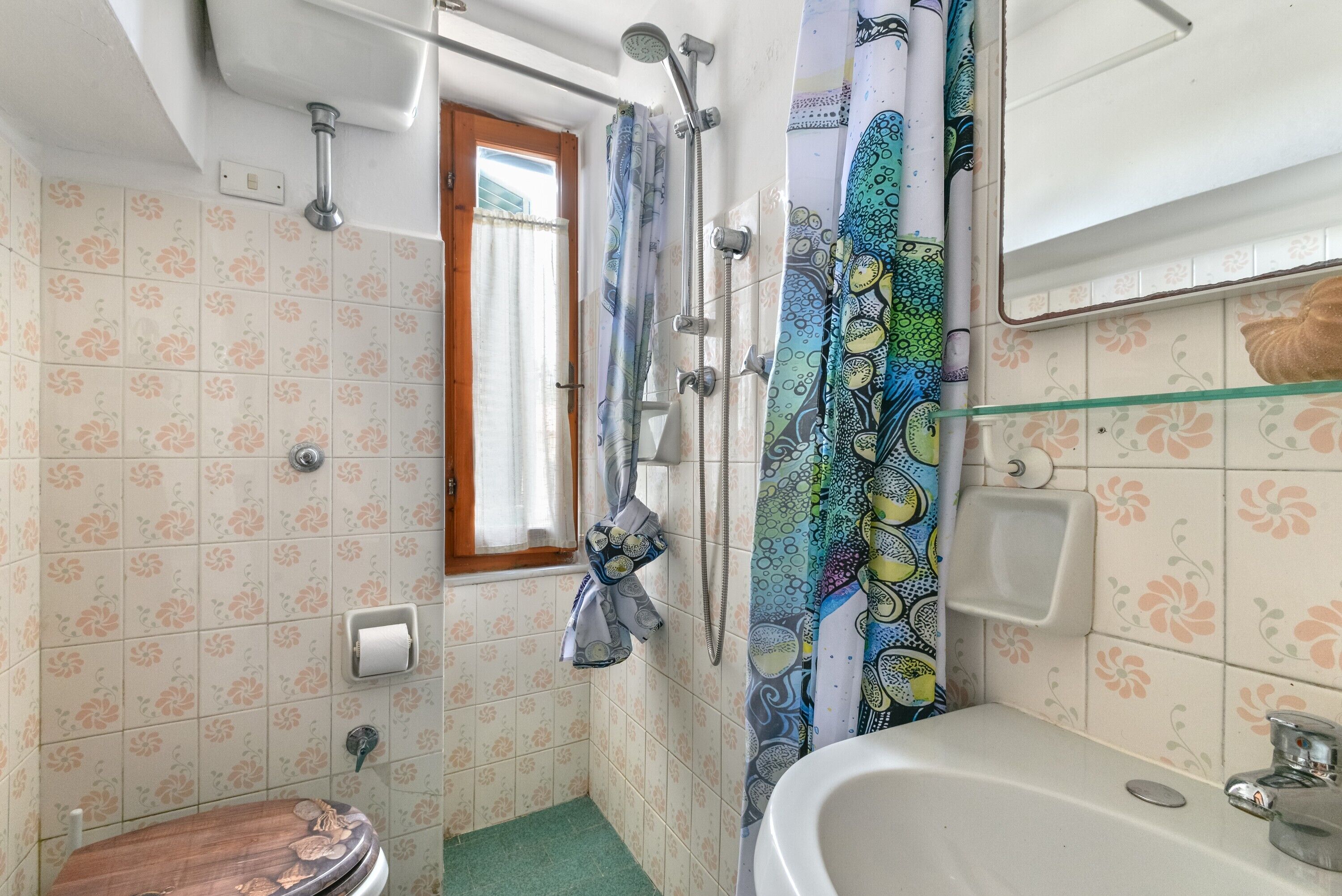A bathroom with a shower, toilet, and sink.
