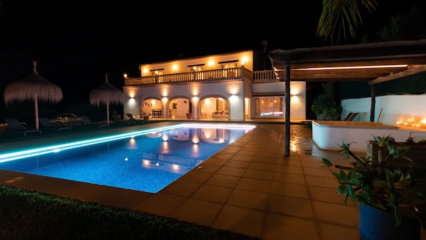 A nighttime view of a hotel with a swimming pool, outdoor seating, and a well-lit facade. - Villa 'Paulina' with Mountain View, Wi-Fi and Air Conditioning (Xàbia)
