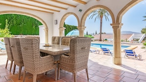 An outdoor patio with wicker furniture, a pool, and a view of the landscape. - Villa 'Cristina' with Mountain View, Wi-Fi and Air Conditioning (Xàbia)
