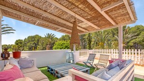 A covered outdoor seating area with wooden furniture and a thatched roof. - Villa 'La Siesta' with Mountain View, Private Pool and Wi-Fi (Xàbia)