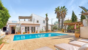 A pool area with lounge chairs, a building with a tiled roof, and potted plants. - Villa 'La Siesta' with Mountain View, Private Pool and Wi-Fi (Xàbia)
