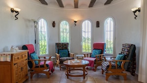A sunlit room with wooden furniture, large windows, and a tiled floor. - Villa 'La Paz' with Private Pool, Shared Terrace and Wi-Fi (El Tosalet)