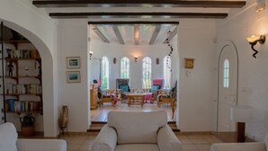 A spacious living room with a fireplace, a bookshelf, and a dining area with chairs and a table. - Villa 'La Paz' with Private Pool, Shared Terrace and Wi-Fi (El Tosalet)