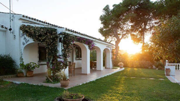 A white building with arches, potted plants, and a grassy area. - Villa 'La Paz' with Private Pool, Shared Terrace and Wi-Fi (El Tosalet)