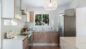Una cucina moderna con isola centrale, elettrodomestici in acciaio inossidabile e un'ampia finestra.