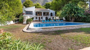 A villa with a swimming pool, surrounded by lush greenery and a mountainous backdrop. - Villa 'Rosa' with Private Pool, Shared Terrace and Wi-Fi (Jávea)