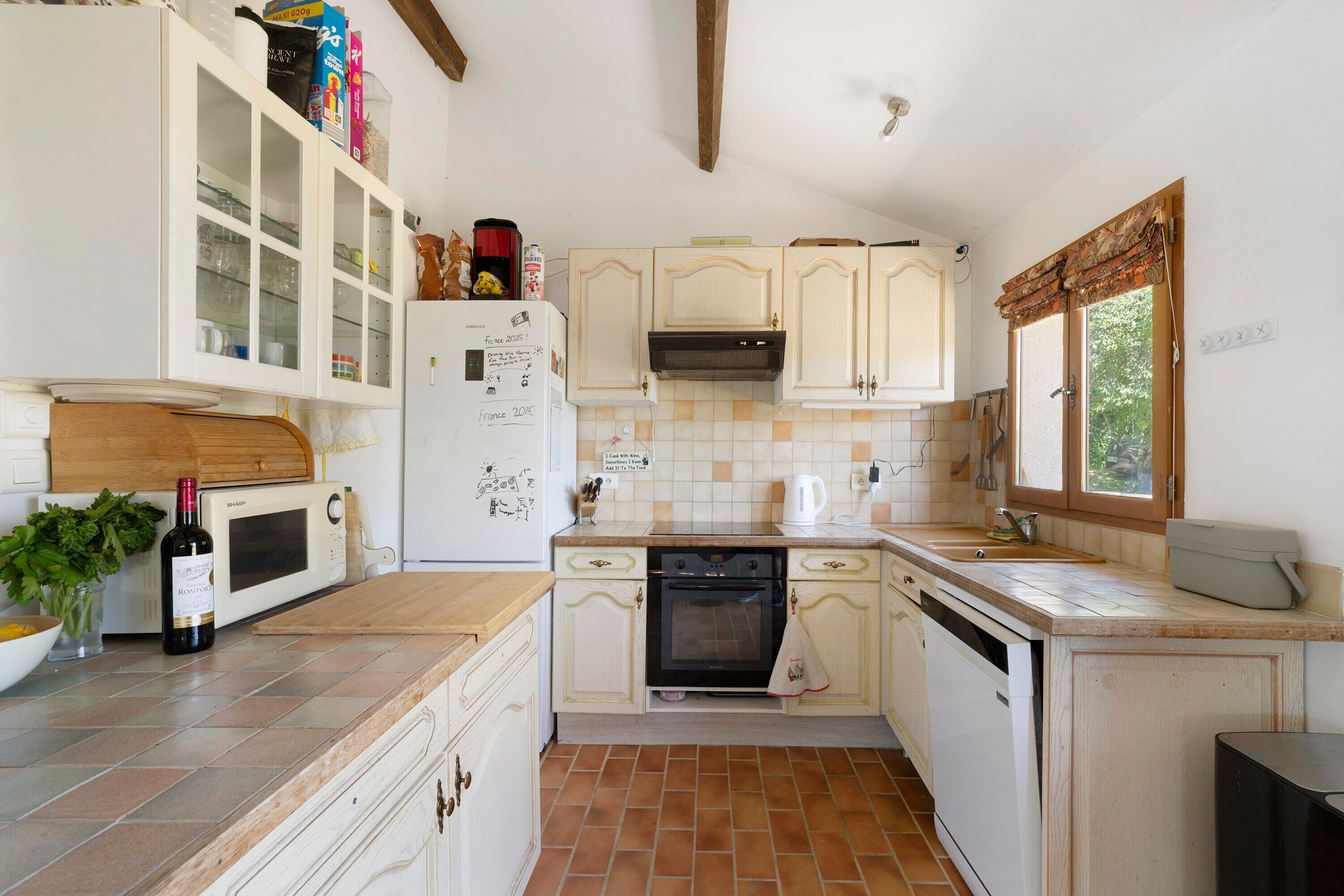 A kitchen with white cabinets, a microwave, a stove, and a sink.