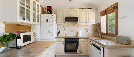 A kitchen with white cabinets, a microwave, a stove, and a sink.