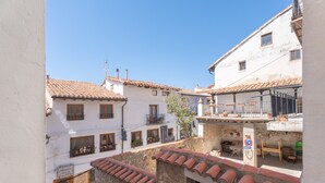 Une rue étroite bordée d’immeubles aux toits de tuiles et aux balcons.