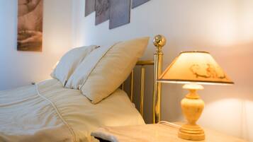 A bed with a headboard, a bedside lamp, and wall art.