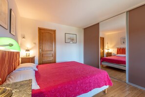 Ein Schlafzimmer mit Bett, Nachttisch, Lampe und Spiegel.
