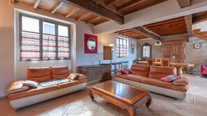 A spacious living room with leather sofas, wooden coffee table, and exposed wooden beams on the ceiling. - Spacious House in Marciac with Private Pool and Terrace (Marciac)