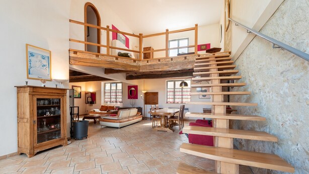 A spacious living area with a wooden staircase, a fireplace, and a dining area. - Spacious House in Marciac with Private Pool and Terrace (Marciac)