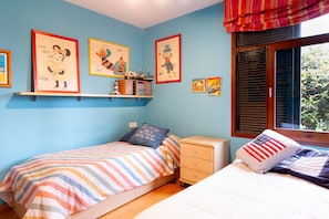 Un dormitorio con dos camas, una mesita de noche, un aparador y decoración en la pared.