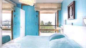 Een kamer met een bed, een raam met uitzicht, een spiegel en een wandklok.