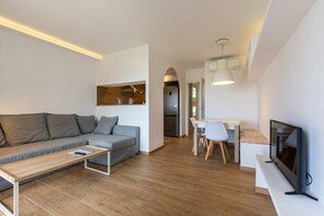 Un salon moderne comprenant un canapé, une table basse, un téléviseur et un coin repas.