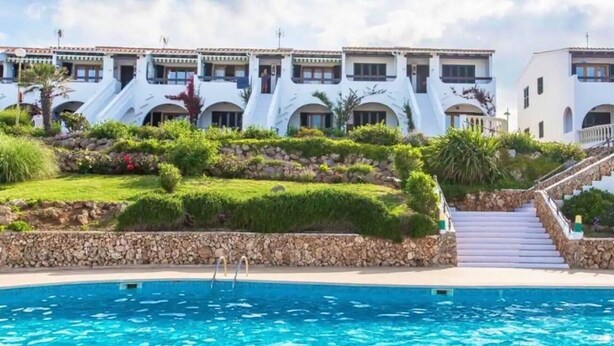 Un hôtel doté d’une piscine, de bâtiments à plusieurs étages et d’un jardin aménagé.