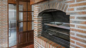 A brick oven with a metal shelf, a wooden door with glass panels, and a stainless steel appliance. - Apartment 'Entrada Rio Lobos Grande' with Mountain View, Private Terrace and Wi-Fi (Hontoria Del Pinar)