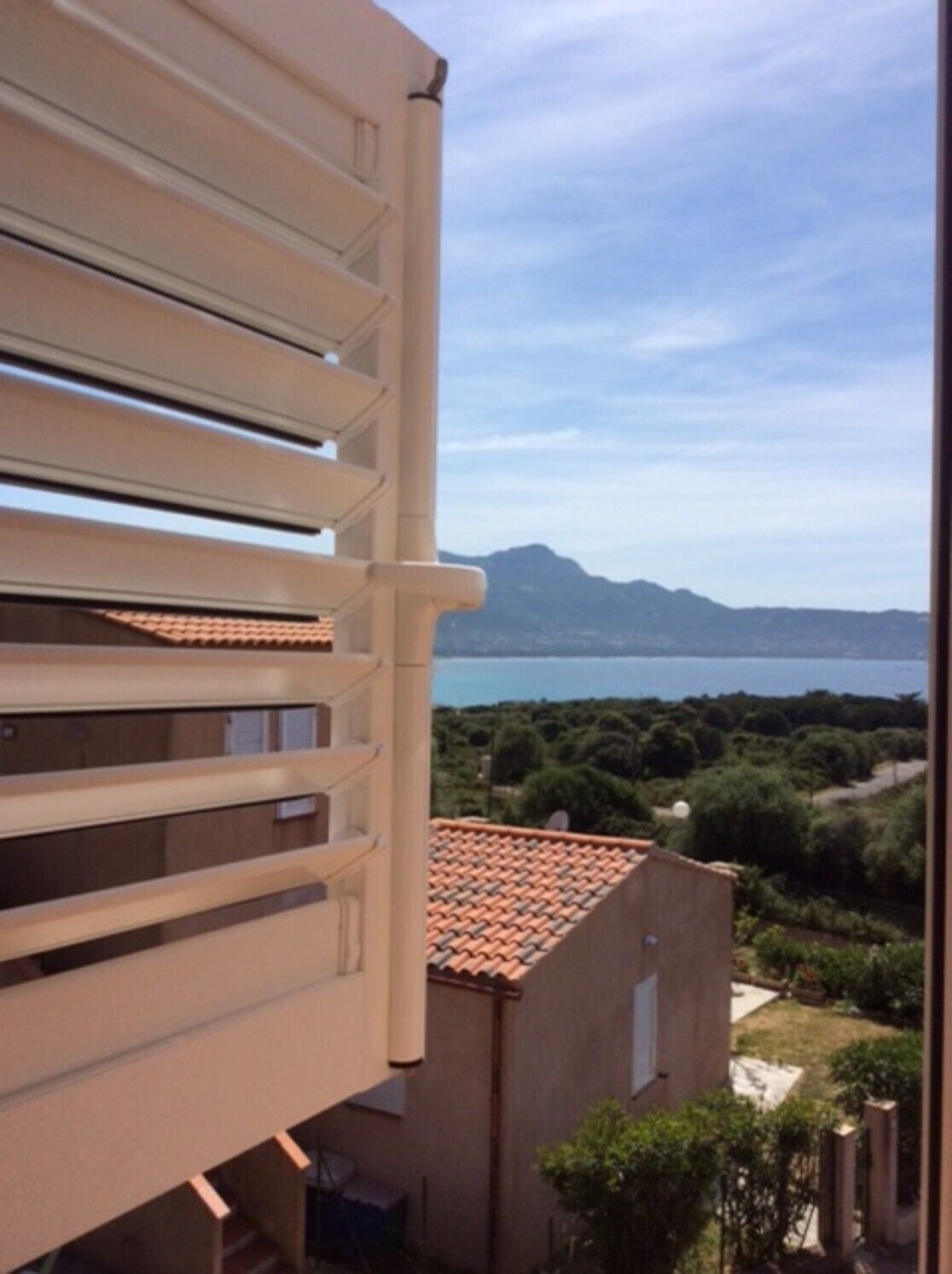 A balcony with a view of a body of water and mountains.