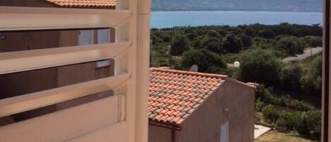 A balcony with a view of a body of water and mountains.