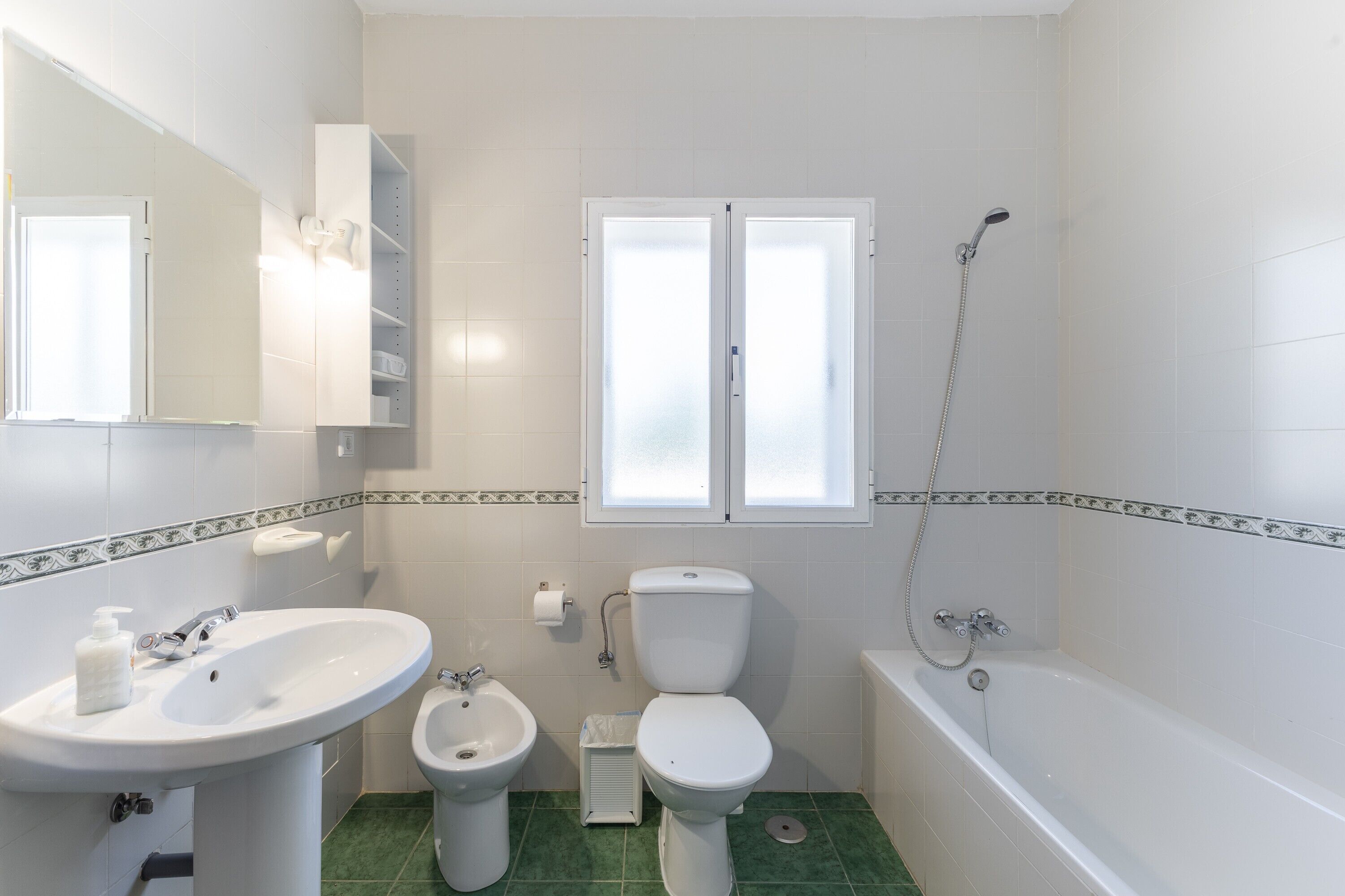 Ein Badezimmer mit Waschbecken, Bidet, Toilette und Badewanne.