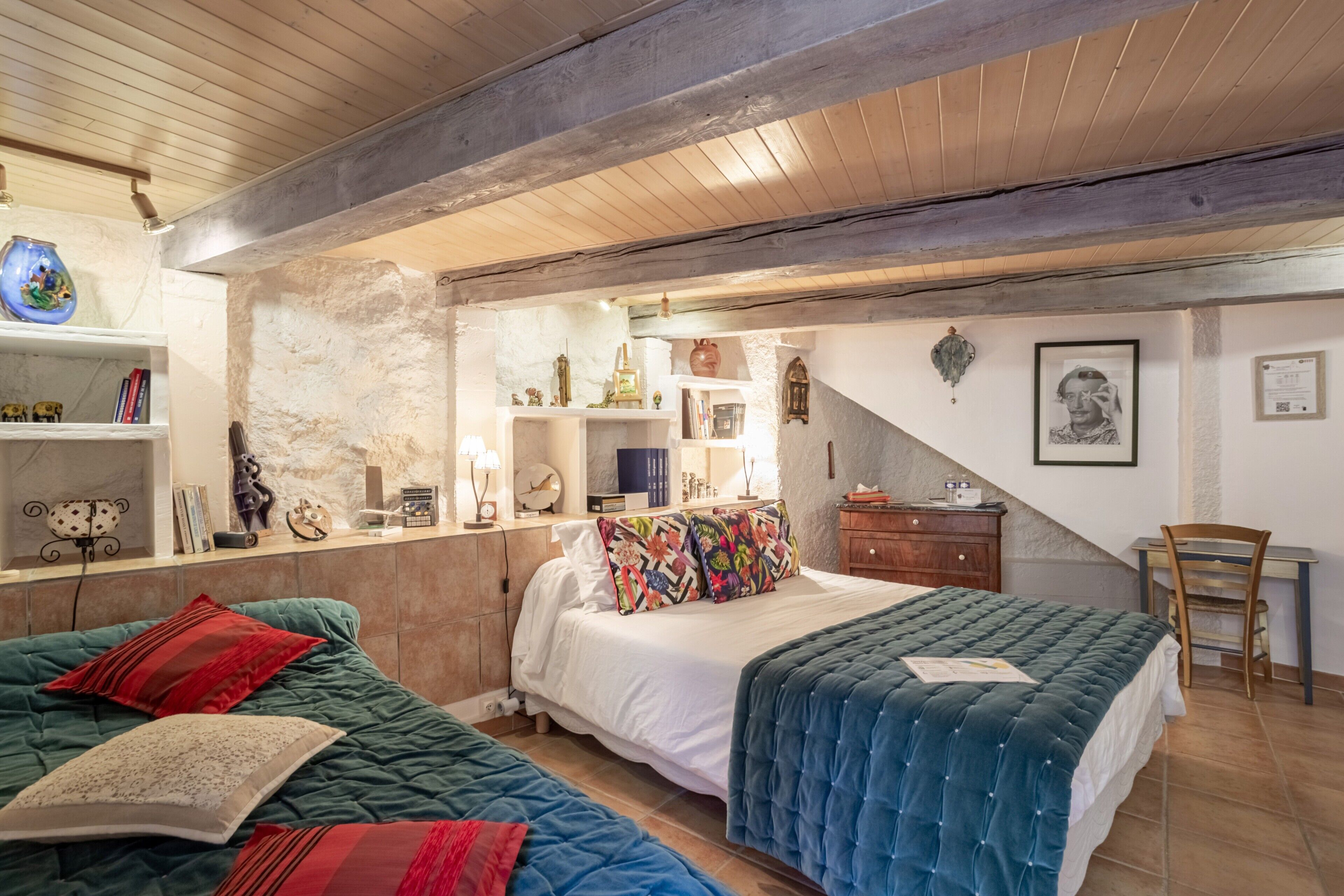 Une chambre à coucher comprenant un lit, deux tables de chevet, une chaise, un bureau et une bibliothèque.