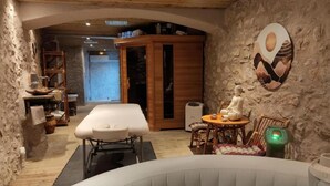 Ein Wellnessraum mit Massagetisch, Whirlpool und Buddha-Statue.