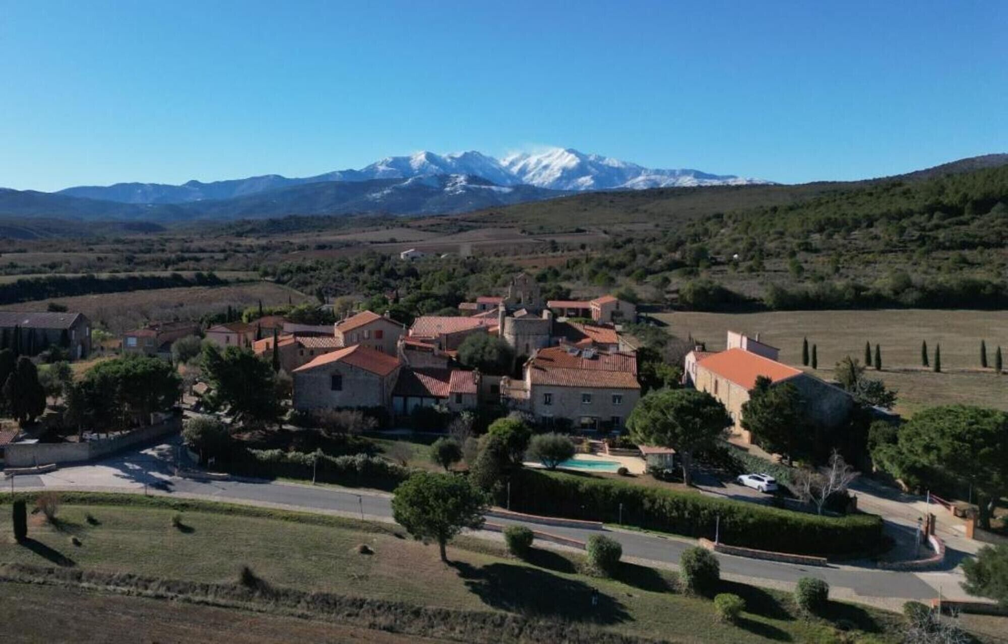 Un pueblo con arquitectura tradicional, una plaza central y una cordillera en el fondo.