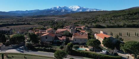 Un pueblo con arquitectura tradicional, una plaza central y una cordillera en el fondo.
