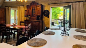 A dining area with a high ceiling, large windows, and a view of the outdoors. - Cozy, comfortable Lakehouse getaway - Sleeps 10! WiFi, Private Dock (Cordele)