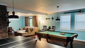 A room with a pool table, a sofa, and a billiards table. - Cozy, comfortable Lakehouse getaway - Sleeps 10! WiFi, Private Dock (Cordele)